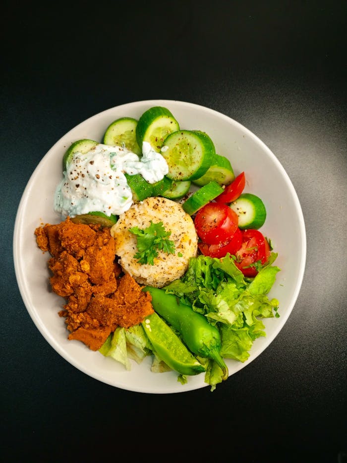 Vibrant Mediterranean bowl with falafel, yogurt sauce, and fresh greens.